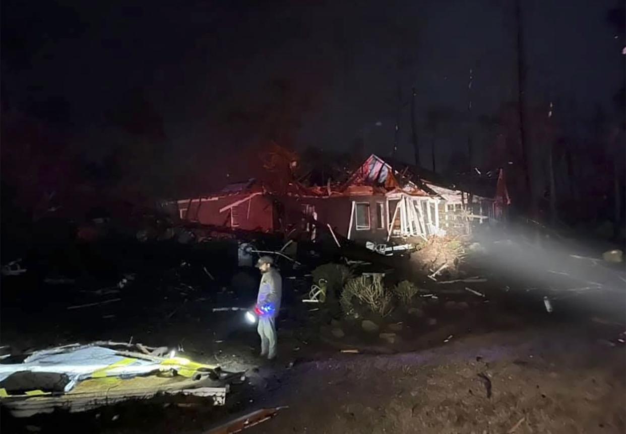 A man surveys the damage after a deadly tornado tore through Brunswick County, N.C. early Tuesday, Feb. 16, 2021. North Carolina authorities say multiple people are dead and others were injured after a tornado ripped through Brunswick County, leaving a trail of heavy destruction.