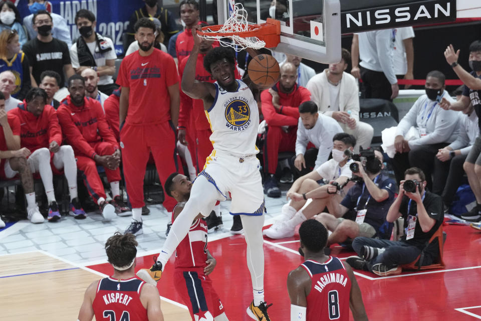 Golden State Warriors' James Wiseman, center, dunks against Washington Wizards during their preseason NBA basketball game, Friday, Sept. 30, 2022, at Saitama Super Arena, in Saitama, north of Tokyo. (AP Photo/Eugene Hoshiko)