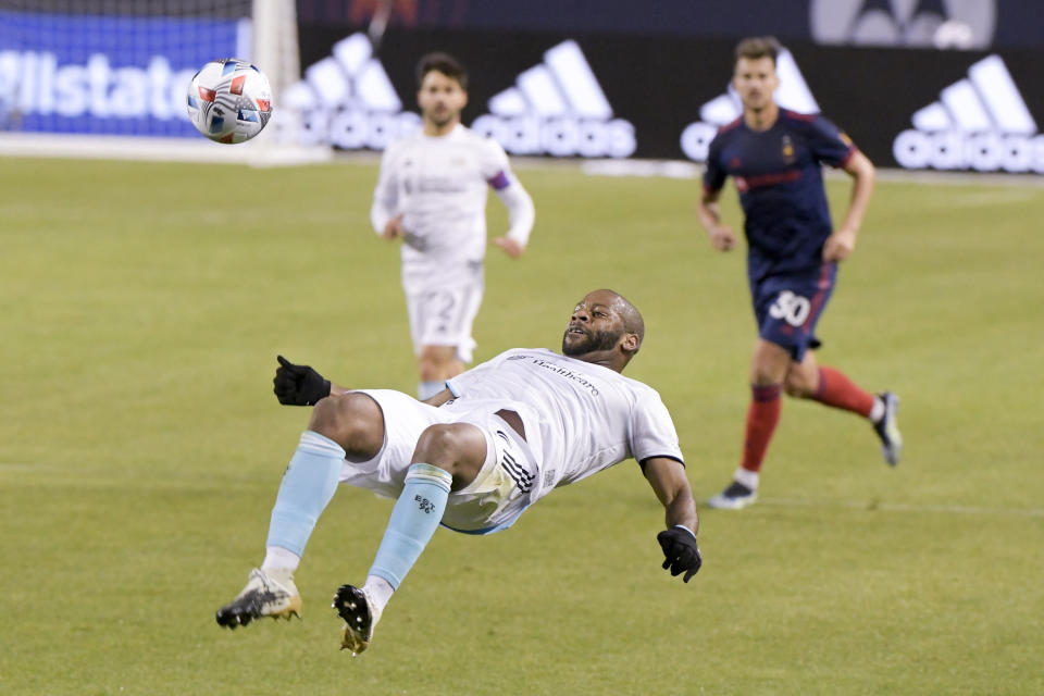 New England Revolution defender Andrew Farrell (2) flips back to kick the ball during the first half of an MLS soccer match against the Chicago Fire in Chicago, Saturday, April 17, 2021. (AP Photo/Mark Black)