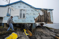 Deputy fire chief Baine Hodder walks past a destroyed house following hurricane Fiona in Burnt Island, Newfoundland and Labrador on Tuesday Sept. 27, 2022. Fiona left a trail of destruction across much of Atlantic Canada, stretching from Nova Scotia's eastern mainland to Cape Breton, Prince Edward Island and southwestern Newfoundland. (Frank Gunn /The Canadian Press via AP)
