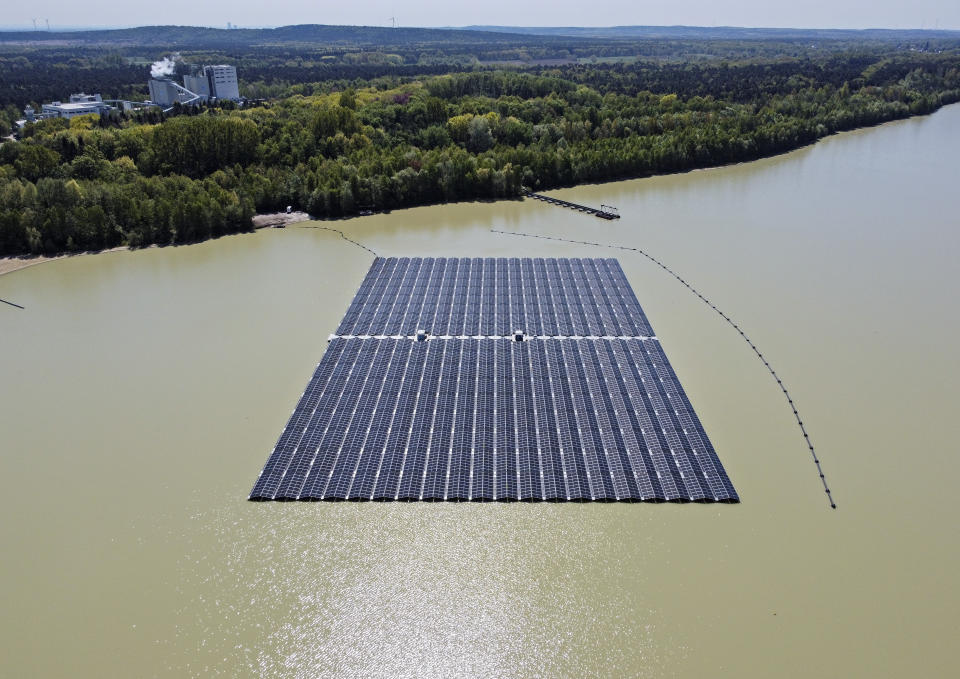 FILE - Solar panels on Germany's biggest floating photovoltaic plant produce energy under a blue sky on a lake in Haltern, Germany, May 3, 2022. Germany, a strong advocate of clean energy, turned to coal and oil to address its short term power needs. (AP Photo/Martin Meissner, File)