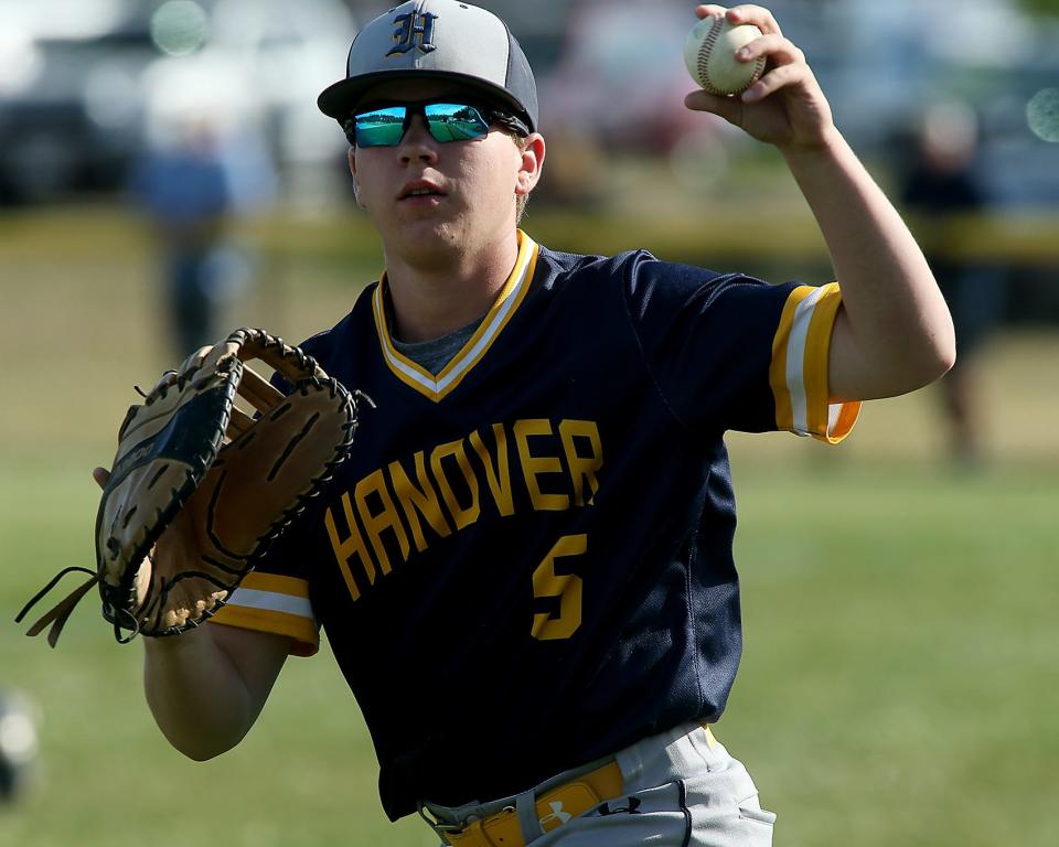 Hanover's Christian Henderson shows the ball to the umpire after making the nice catch over the fence in foul territory in the bottom of the fourth inning of a game against Marshfield at Marshfield High School on Thursday, May 26, 2022.