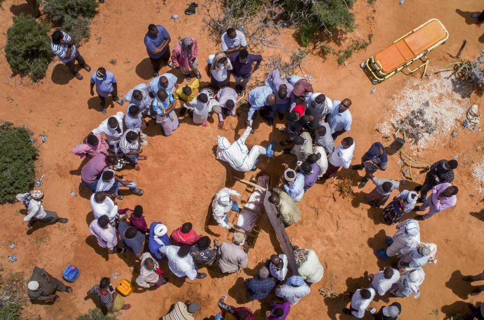 In this photo taken Thursday, April 30, 2020, medical workers in protective suits bury the body of an elderly man believed to have died from the coronavirus in Mogadishu, Somalia. Years of conflict, instability and poverty have left Somalia ill-equipped to handle a health crisis like the coronavirus pandemic. The uncertainty has led to fear, confusion and panic even after authorities have tried to keep the public informed about the outbreak. (AP Photo)