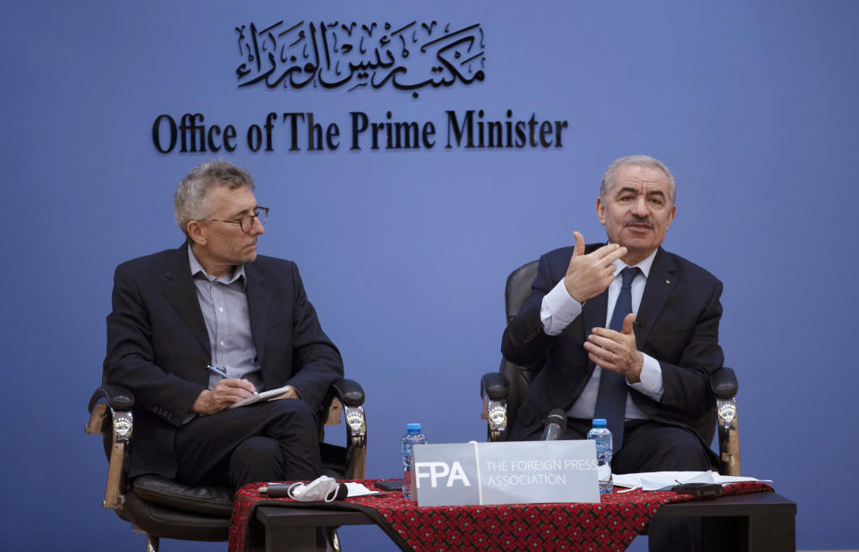 Palestinian Prime Minister Mohammad Shtayyeh, right, holds a briefing with foreign press alongside Andrew Carey, chairman of the Foreign Press Association (FPA), in the West Bank city of Ramallah, Wednesday, Nov. 10, 2021. (AP Photo/Majdi Mohammed)