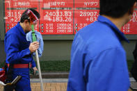 Workers walk past an electronic stock board showing Japan's Nikkei 225 index at a securities firm in Tokyo Tuesday, Jan. 14, 2020. Asian shares followed Wall Street higher on Tuesday amid optimism that a trade deal between the U.S. and China will be a boon for the regional economy. (AP Photo/Eugene Hoshiko)