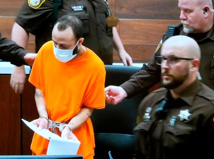 Darrell Brooks, appearing via video in an adjacent courtroom after being removed for continuous interruptions, is taken away by Waukesha County Sheriffs' Department deputies after he Judge Jennifer Dorow gave him six consecutive life sentences without the possibility for parole.