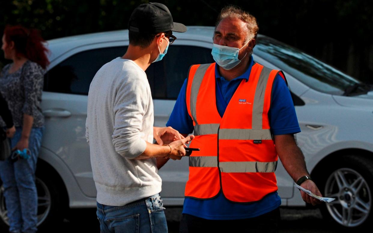 An employee of the NHS Test and Trace programme talks to a man who arrived with an appointment to get a test at a Covid-19 testing site after they had closed down the site for the day in Catford, southeast London, on September 17, 2020. - People who arrived at the testing site in Catford in southeast London who had appointments for a Covid-19 test were turned away because they were not in possession of a QR Code with their appointment, they said. The testing site closed down their operation with members of the public still arriving by car and on foot with long tailbacks causing delays on the South Circular.  - DANIEL SORABJI/AFP/Getty