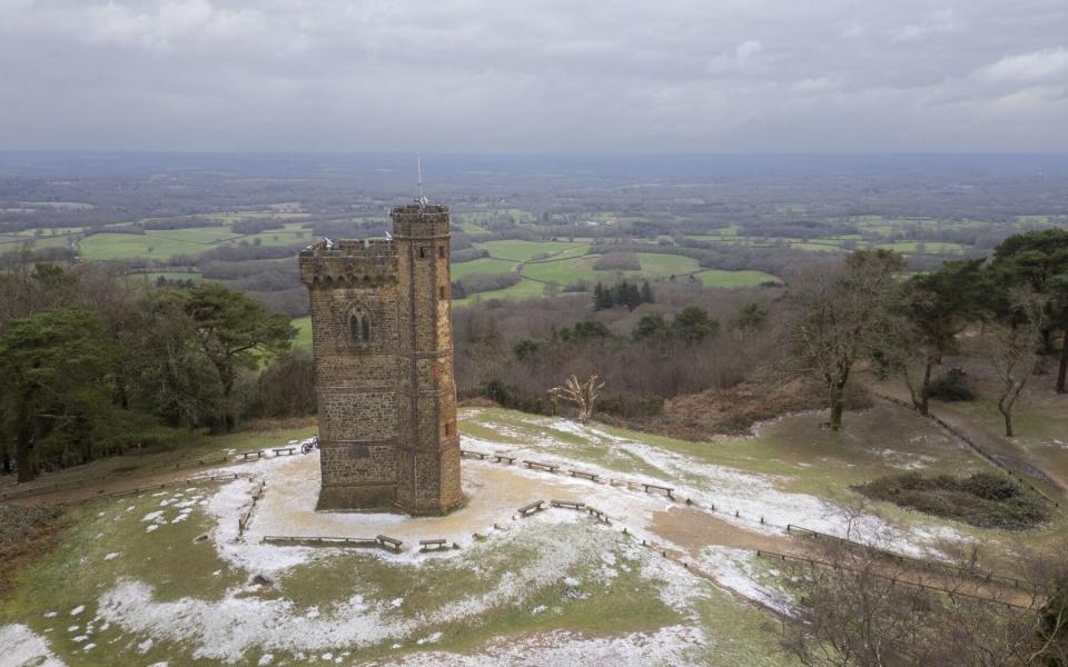 Snow begins to settle on the ground surrounding Leith Hill Tower in the Leith Hill area of Surrey