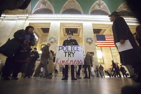 A protester stands with a sign as he joins a protest to demand justice for the death of Eric Garner, at Grand Central Terminal in the Manhattan borough of New York, December 9, 2014. REUTERS/Carlo Allegri