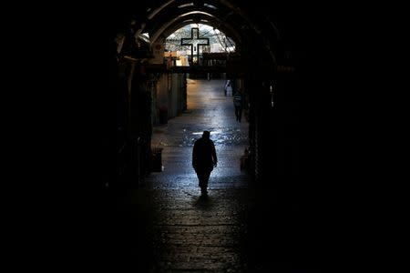 A priest walks down an ally in the Christian Quarter of Jerusalem's Old City June 21, 2016. REUTERS/Ronen Zvulun