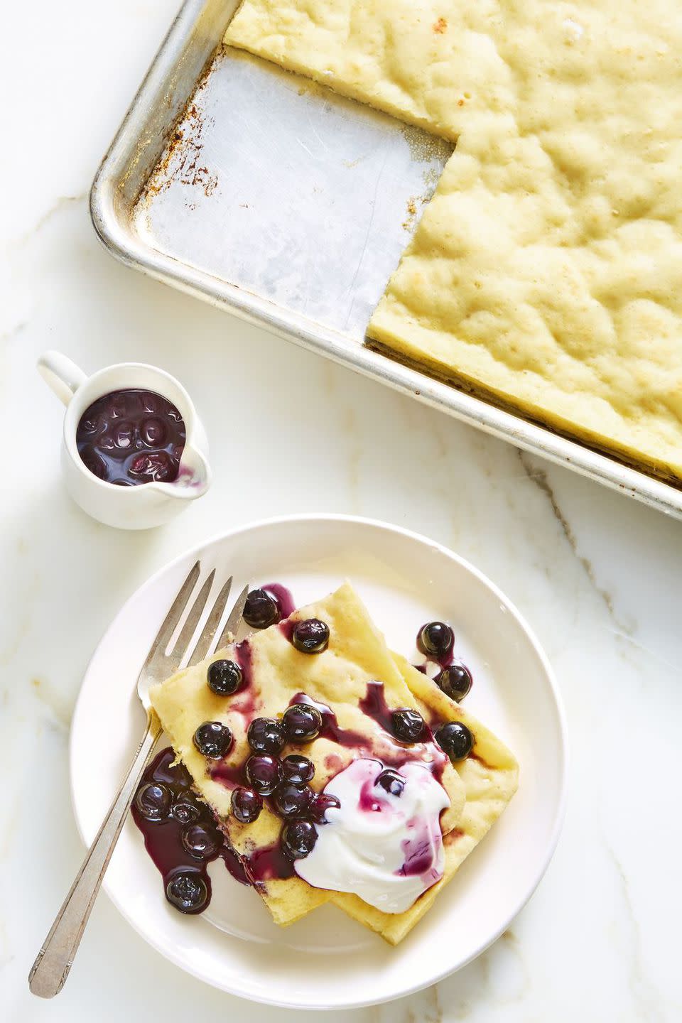 <p>Instead of standing over the oven and flipping pancakes for 20 minutes straight, put this pan in the oven for 15 minutes while you prepare the rest of the feast.</p><p><strong>Get the recipe at <a rel="nofollow noopener" href="https://www.goodhousekeeping.com/food-recipes/a22750828/sheet-pan-pancake-with-blueberry-syrup-recipe/" target="_blank" data-ylk="slk:Good Housekeeping;elm:context_link;itc:0;sec:content-canvas" class="link ">Good Housekeeping</a>.</strong></p>