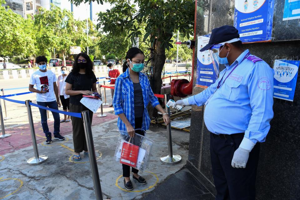 A student gets her temperature taken as she arrives at an examination centre for Joint Entrance Examination (JEE ) Main-2020, one of the most competitive entrance exams for entry to top national engineering colleges, in Noida on September 1, 2020. (Photo by Prakash SINGH / AFP) (Photo by PRAKASH SINGH/AFP via Getty Images)