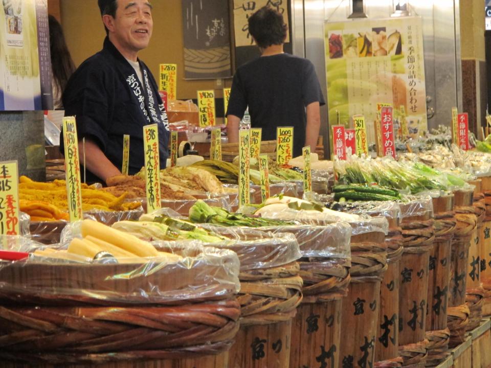 In this August 2012 photo, a vendor mans a stand selling a wide variety of pickled vegetables in the Nishiki-koji market arcade in Kyoto, Japan. Many of the market’s merchants offer free samples to entice customers. (AP Photo/Adam Geller)