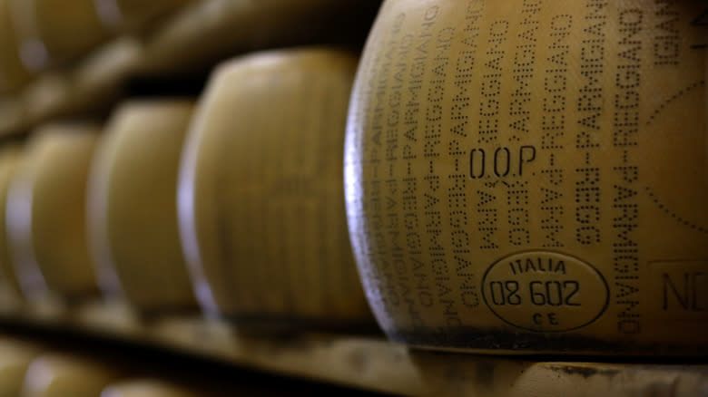 wheels of Italian parmesan cheese on a shelf