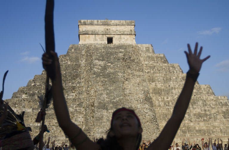 Visitors raise their hands during celebrations for the end of the Mayan cycle known as Bak'tun 13 and the start of the Maya new age, at the Chichen Itza archaeological park, in Yucatan state, Mexico on December 21, 2012. A global day of lighthearted doom-themed celebration and superstitious scare-mongering culminated at the temples of the Mayan people, whose calendar sparked fears of apocalypse