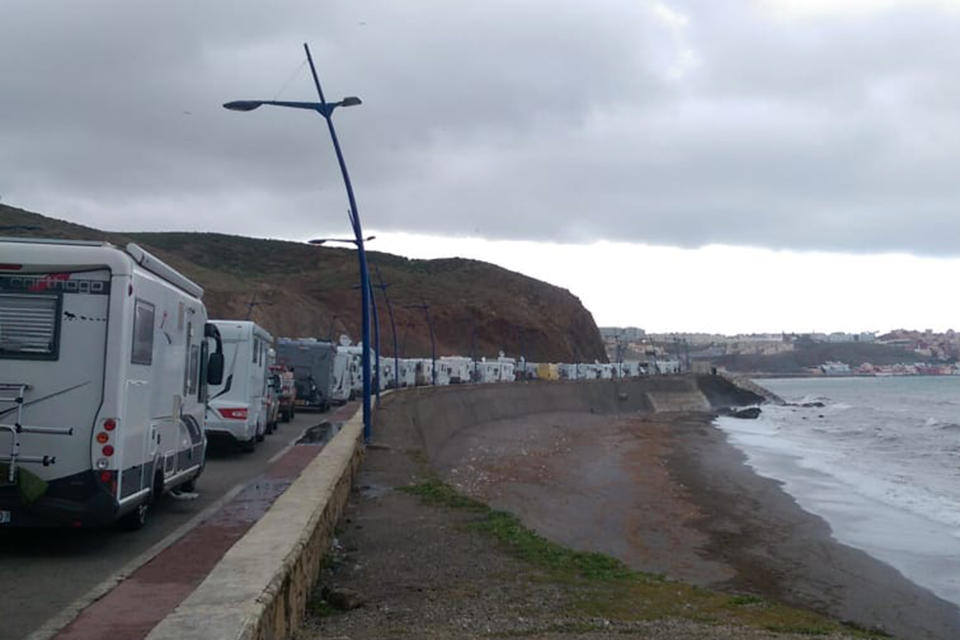 In this photo taken on Tuesday, March 24, 2020, stranded tourists in motor homes queue in northern Morocco, near the Spanish enclave of Ceuta. Tourists were stranded in the region due to a lockdown and other strict measures taken by Moroccan authorities to limit the spread of the coronavirus. The new coronavirus causes mild or moderate symptoms for most people, but for some, especially older adults and people with existing health problems, it can cause more severe illness or death. (Andy McKettrick via AP)