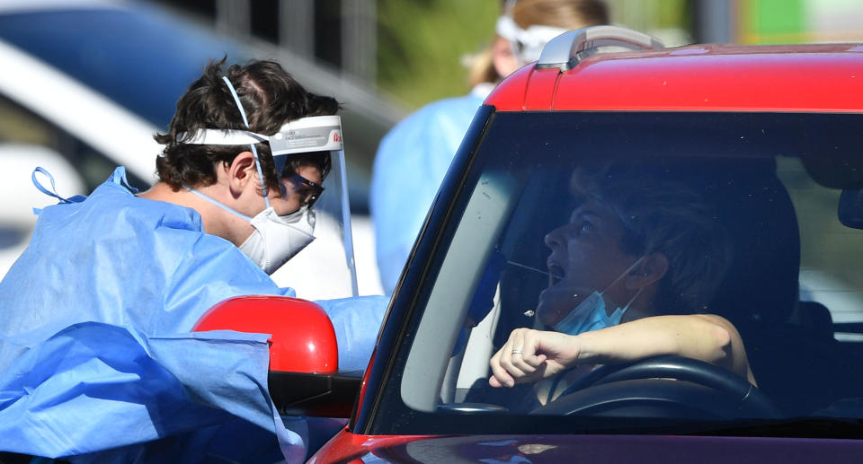 Health care workers are seen testing people at a pop-up COVID-19 testing centre at St Thomas More College in the suburb of Sunnybank in Brisbane, Saturday, September 11, 2021. Source: AAP