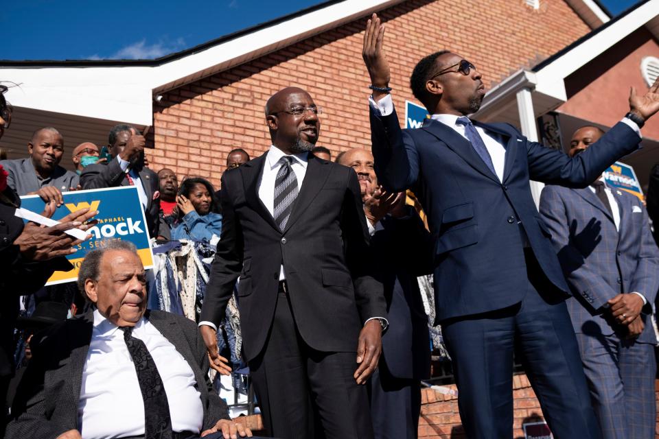 Sen. Raphael Warnock, D-Ga., center, prepares to speak at a rally after being introduced by Civil Rights icon Andrew Young, left, and Atlanta Mayor Andre Dickens on Sunday, Nov. 27, 2022, in Atlanta.