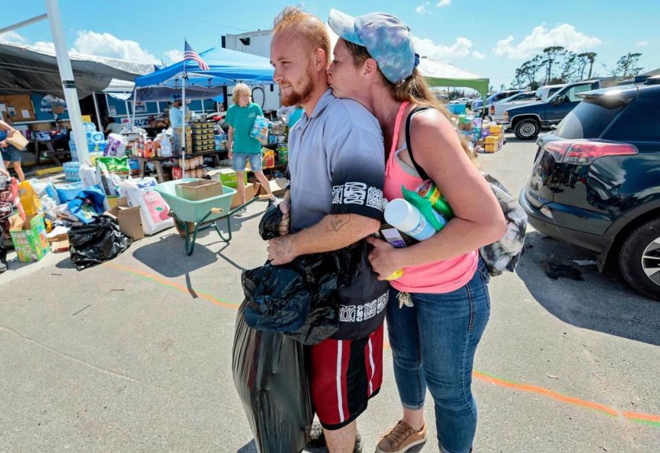 Hurricane Ian survivors, Jodi Lawhead, 41, kisses Ryan Davis, 27, after picking up relief supplies in St. James City, an unincorporated community, on Pine Island on Tuesday, Oct. 4, 2022.