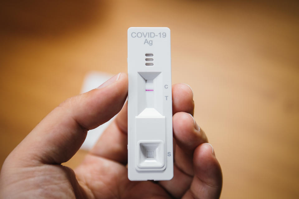 A man holds a Covid rapid antigen test in his hand. 