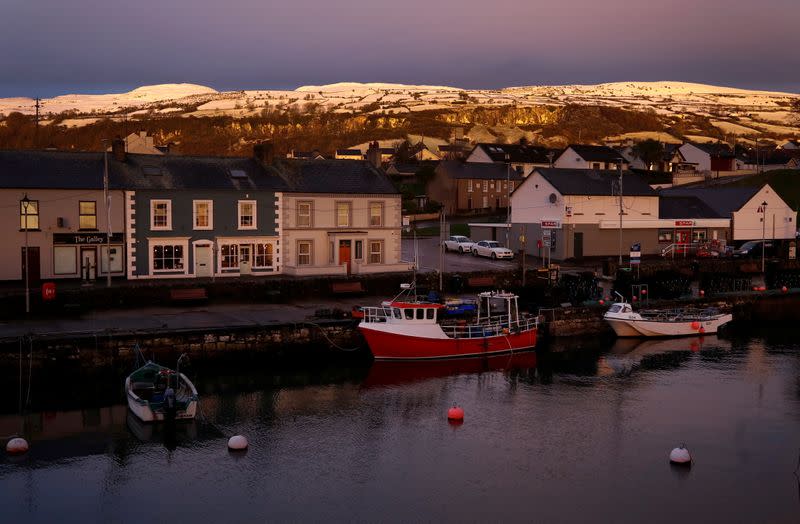 Sun rises over the Irish Sea fishing village of Carnlough