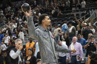 San Antonio Spurs forward Victor Wembanyama throws a small basketball with his signature into the stands after an NBA basketball game against the Detroit Pistons, Sunday, April 14, 2024, in San Antonio. Wembanyama did not play in the game. (AP Photo/Michael Thomas)