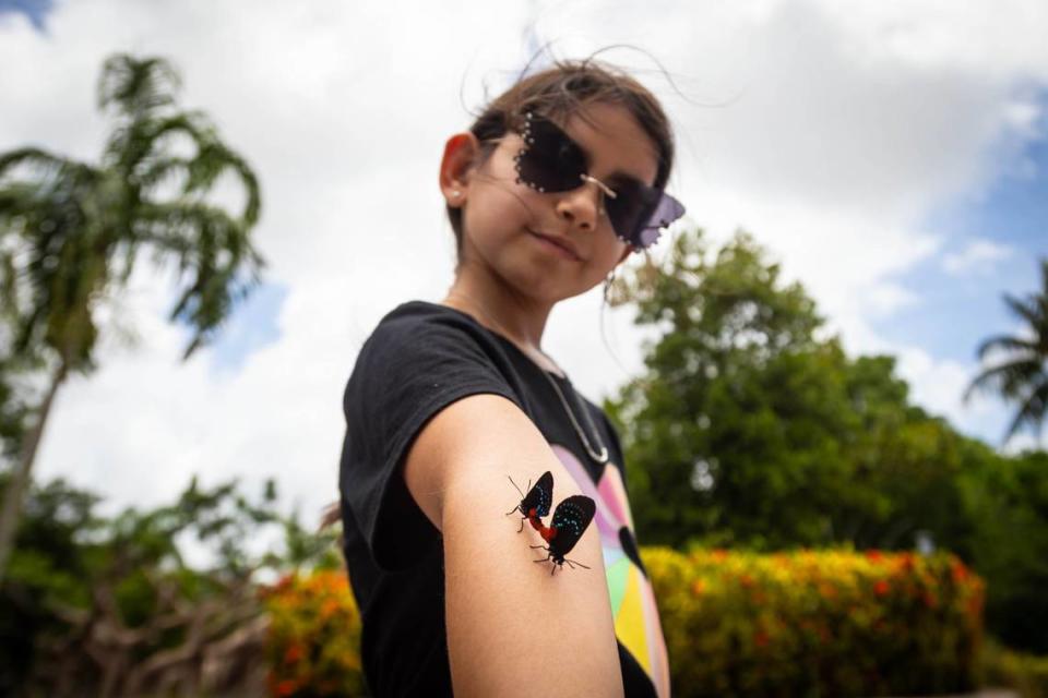 Alice Banchon, 8, poses with two atala butterflies after their release outside of Zoo Miami’s Conservation Action Center on Thursday, June 20, 2024 in Miami, Fla.