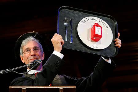 Marc Abrahams, Master of ceremonies and editor of the Annals of Improbable Research, holds one of this year's prizes at the 24th First Annual Ig Nobel Prizes awards ceremony at Harvard University in Cambridge, Massachusetts September 18, 2014. REUTERS/Brian Snyder