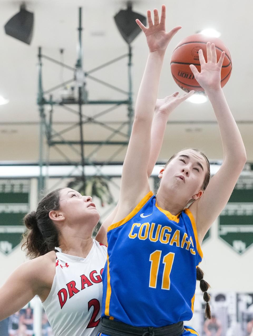 Greenfield-Central Cougars guard Izzy Silcox (11) goes in for a lay-up against New Palestine Dragons guard Kylee Beranek (23) on Wednesday, Jan. 31, 2024, during the game at Pendleton Heights High School in Pendleton. The New Palestine Dragons defeated the Greenfield-Central Cougars, 42-35.