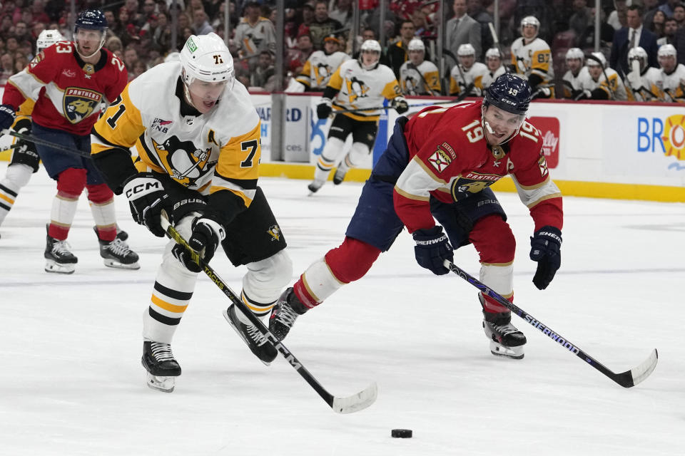 Pittsburgh Penguins center Evgeni Malkin (71) skates with the puck as Florida Panthers left wing Matthew Tkachuk (19) defends during the first period of an NHL hockey game, Friday, Dec. 8, 2023, in Sunrise, Fla. (AP Photo/Lynne Sladky)