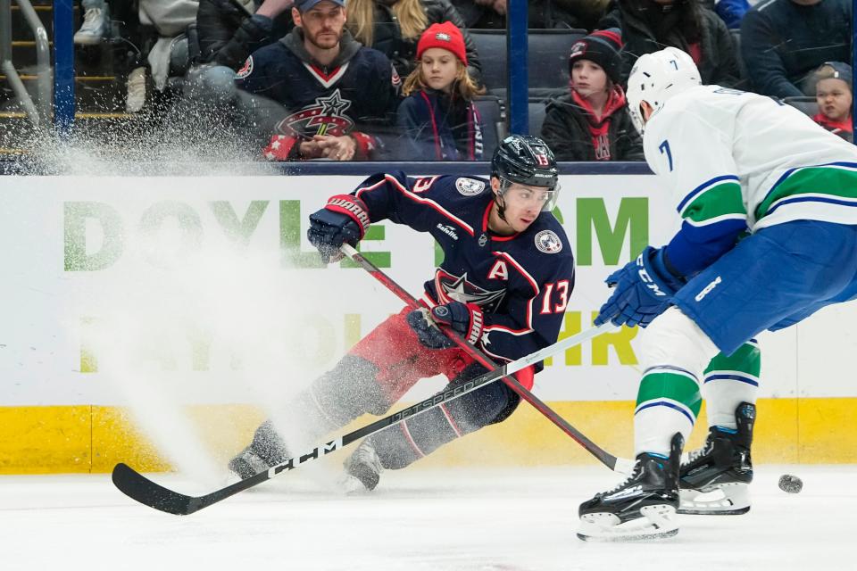 Jan 15, 2024; Columbus, Ohio, USA; Columbus Blue Jackets left wing Johnny Gaudreau (13) skates around Vancouver Canucks defenseman Carson Soucy (7) during the third period of the NHL hockey game at Nationwide Arena. The Blue Jackets won 4-3 in a shootout.