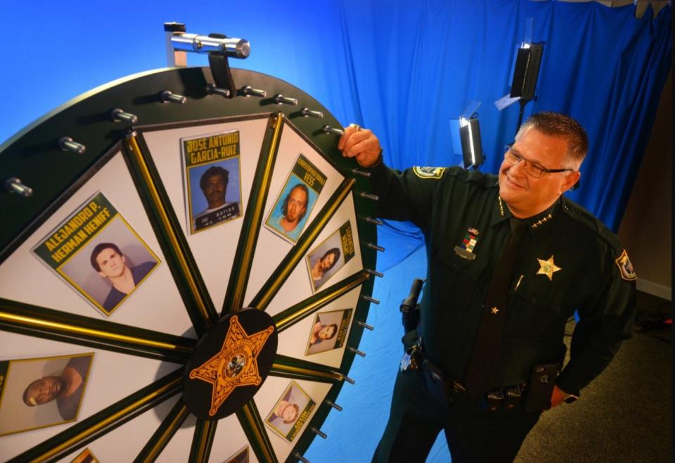 Brevard County Sheriff Wayne Ivey demonstrates the 'Wheel of Fugitive' board in 2017.