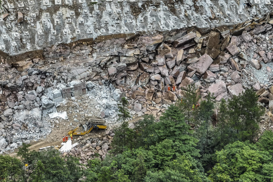 In this photo released by Xinhua News Agency, rescuers conduct a search and rescue operation at a landslide area at a highway construction site in Yueshan Village under Tujia Autonomous County of Wufeng in central China's Hubei Province Sunday, July 9, 2023. Rescuers were looking Monday for seven people missing in a landslide triggered by torrential rains while employers across much of China were ordered to limit outdoor work due to scorching temperatures as the country struggled with heat, flooding and drought. (Wu Zhizun/Xinhua via AP)