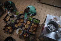 Zoo keepers Alexis left and Christina prepare food for the animals in the Attica Zoological Park in Spata, near Athens, on Tuesday, Jan. 26, 2021. (AP Photo/Petros Giannakouris)