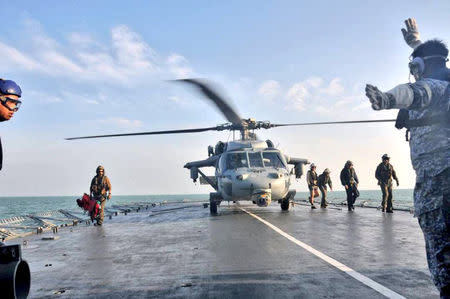 U.S. Navy helicopter from USS America lands on Royal Malaysia Navy's KD Lekiu Frigate 30 during a search and rescue operation for survivors of the USS John S. McCain ship collision in Malaysian waters in this handout photo distributed August 23, 2017. Royal Malaysian Navy Handout via REUTERS