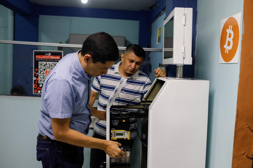 Edgar Borja and Edwin Escobar check the parts of a K1 ATM prototype, which is designed for handling cash, card payments, Bitcoin and receiving remittances, in Santa Tecla, El Salvador June 25, 2021. REUTERS/Jose Cabezas