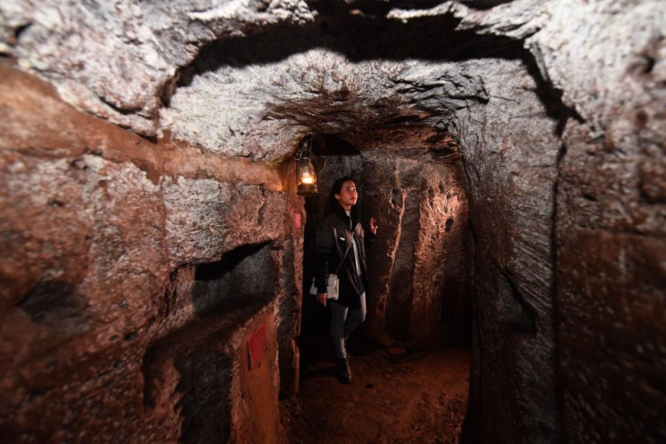 A photo of a woman walking in underground tunnels.