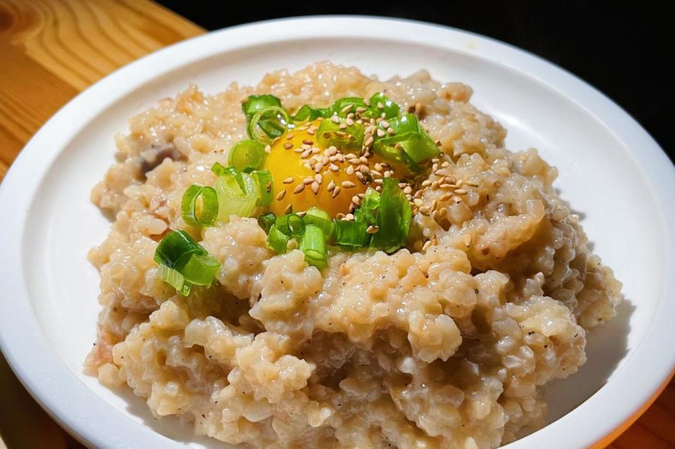 A bowl of chicken nurungji topped with egg yolk, green onion and sesame at Jilli in Koreatown