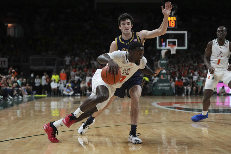 Miami guard Bensley Joseph (4) drives past Notre Dame guard Logan Imes (2) during the first half of an NCAA college basketball game, Saturday, Dec. 2, 2023, in Coral Gables, Fla. (AP Photo/Jim Rassol)