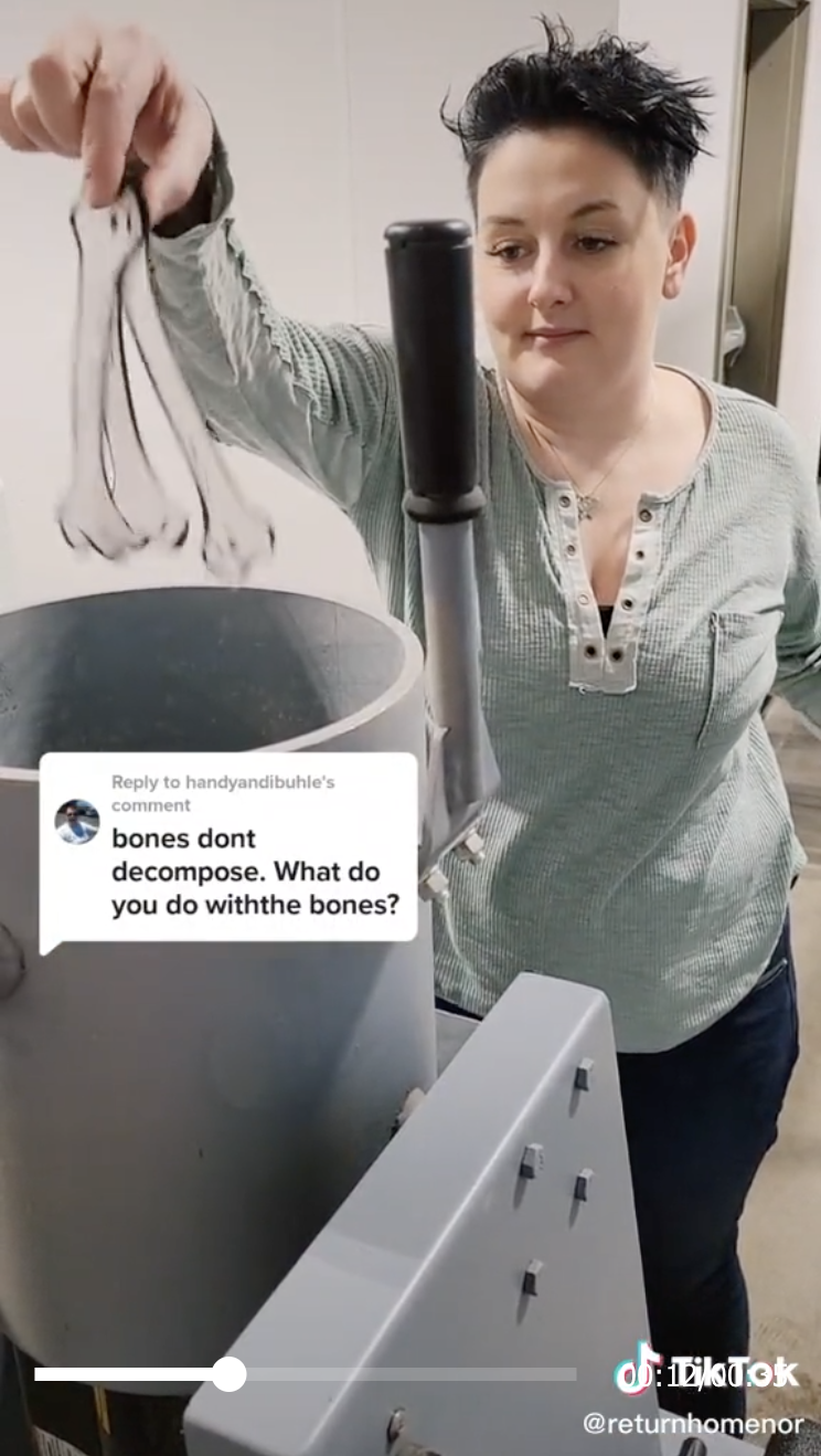 Katey dropping fake bones into a large vat connected to machinery