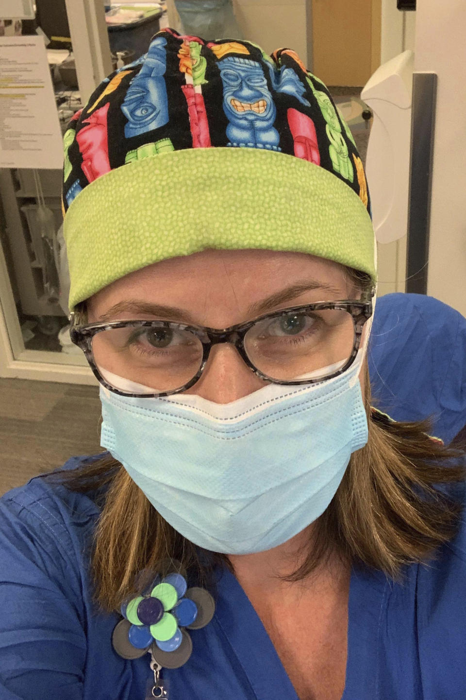 In this undated photo provided by Cassie Docking, she takes a selfie at work as an urgent care nurse in Seattle. She is telling her parents — both cancer survivors — that Thanksgiving will be by FaceTime only. “We all want to get to 2021 and if that’s what it takes, that’s what we’ll do,” Docking said. (Courtesy of Cassie Docking via AP)