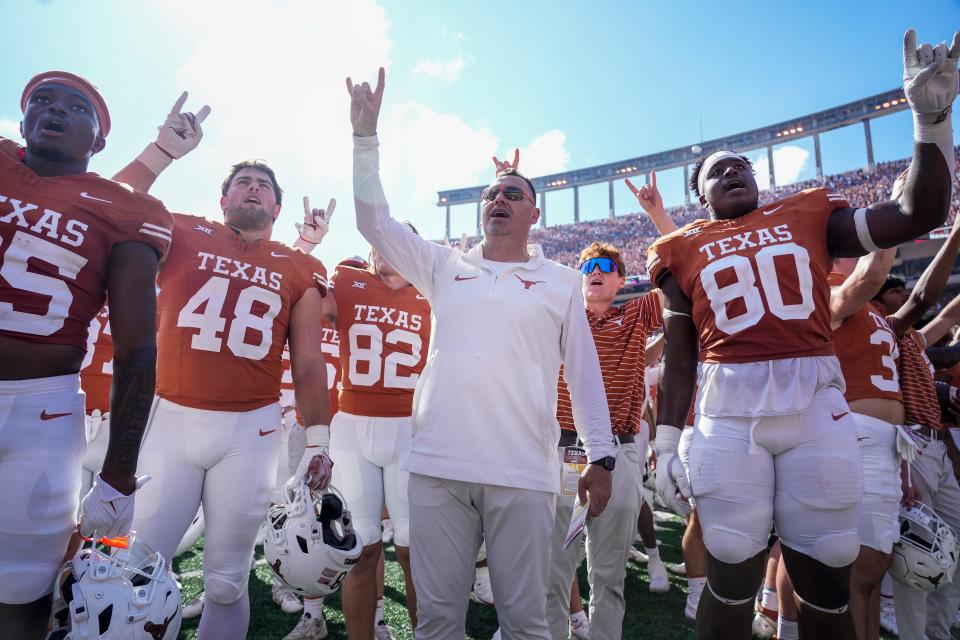 Texas head coach Steve Sarkisian celebrates Saturday's 33-30 overtime win over Kansas State along with his players at Royal-Memorial Stadium. The Horns travel to Fort Worth to take on TCU on Saturday.