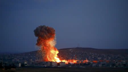 Smoke and flames rise over Syrian town of Kobani after an airstrike, as seen from the Mursitpinar border crossing on the Turkish-Syrian border in the southeastern town of Suruc in Sanliurfa province, October 18, 2014. REUTERS/Kai Pfaffenbach