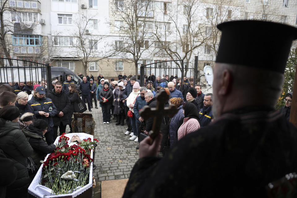 Family members of Vitaliy Alimov mourn over his body during his funeral in Bilhorod-Dnistrovskyi, Ukraine, Monday March 18, 2024. Alimov, a firefighter, was killed in the Russian attack on Odesa on Friday March 15. (AP Photo/Victor Sajenko)