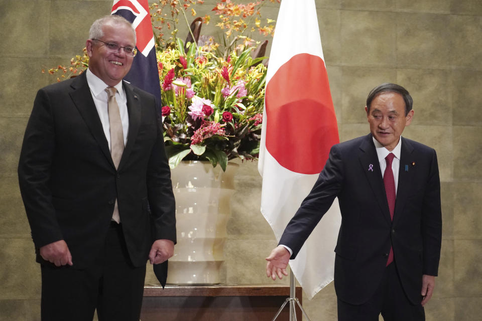 Australian Prime Minister Scott Morrison, left, is escorted by Japanese Prime Minister Yoshihide Suga prior to the official welcome ceremony at Suga's official residence in Tokyo Tuesday, Nov. 17, 2020. Morrison is in Japan to hold talks with Suga to bolster defense ties between the two U.S. allies to counter China’s growing assertiveness in the Asia-Pacific region. (AP Photo/Eugene Hoshiko, Pool)