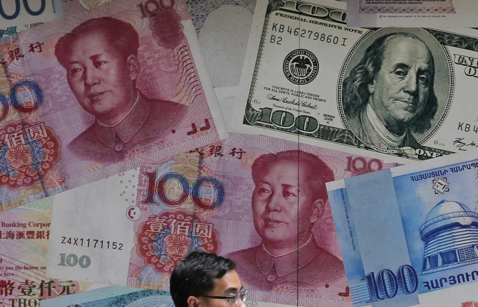 FILE - In this June 10, 2019, file photo, a man walks past a money exchange shop decorated with different banknotes at Central, a business district of Hong Kong. The U.S. Treasury Department labeled China a currency manipulator Monday, Aug. 5, after Beijing pushed down the value of its yuan in a dramatic escalation of the trade conflict between the world's two biggest economies. (AP Photo/Kin Cheung, File)