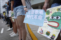 Protesters hold a placard which reads "Recover Hong Kong, an era's revolution" as they form a human chain outside the Queen Elizabeth Stadium in Hong Kong, Thursday, Sept. 26, 2019. Riot police on Thursday begun securing a stadium in downtown Hong Kong ahead of a town hall session by embattled city leader Carrie Lam, aimed at cooling down months of protests for greater democracy in the semi-autonomous Chinese territory. (AP Photo/Vincent Thian)