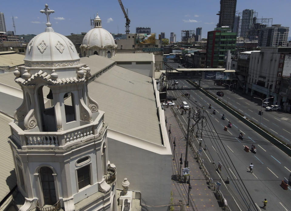 Devotees walk outside the closed Quiapo church to say a brief prayer on Good Friday, April 2, 2021 as the government implements a strict lockdown to prevent the spread of the coronavirus in Manila, Philippines. Filipinos marked Jesus Christ's crucifixion Friday in one of the most solemn holidays in Asia's largest Catholic nation which combined with a weeklong coronavirus lockdown to empty Manila's streets of crowds and heavy traffic jams. Major highways and roads were eerily quiet on Good Friday and churches were deserted too after religious gatherings were prohibited in metropolitan Manila and four outlying provinces. (AP Photo/Aaron Favila)