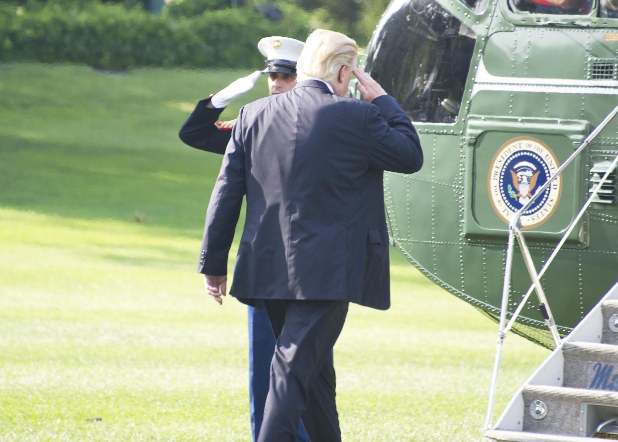 US President Donald Trump salutes the Marine Guard as he departs the White House: Getty Images