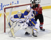 New Jersey Devils right wing Kyle Palmieri (21) checks Buffalo Sabres defenseman Matthew Irwin (44) into Sabres goaltender Linus Ullmark (35) during the third period of an NHL hockey game Tuesday, Feb. 23, 2021, in Newark, N.J. The Sabres won 4-1.(AP Photo/Bill Kostroun)